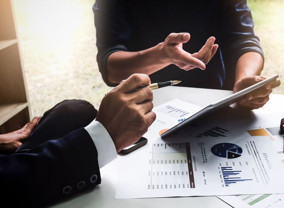 Business people using pen,tablet,notebook are planning a marketing plan to improve the quality of their sales in the future. Education Concept