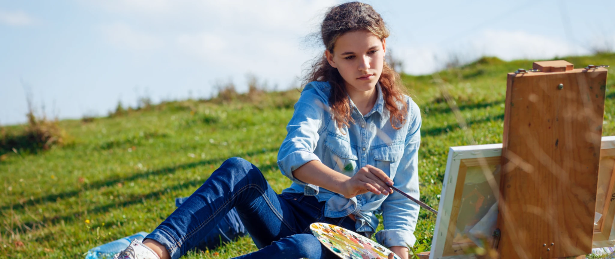 Student participating in creative activities during a Swiss summer camp in a natural outdoor environment